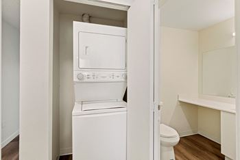 a white washer and dryer in a room with a toilet